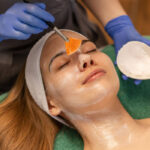 relaxed woman receiving a facial from a provider
